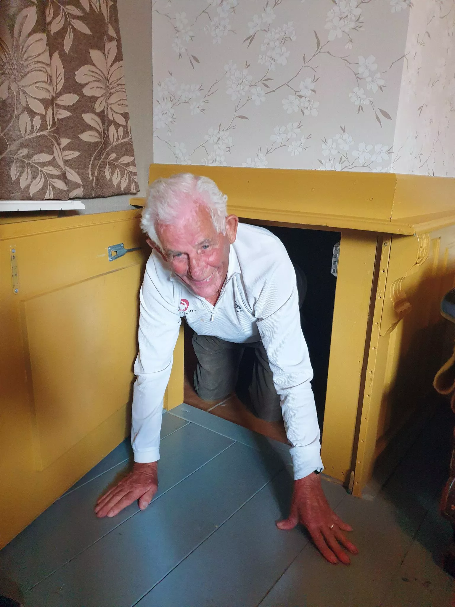 Oude man kruipt door geheime tunnel tijdens escaperoom in een Tweede Wereldoorlog Museum