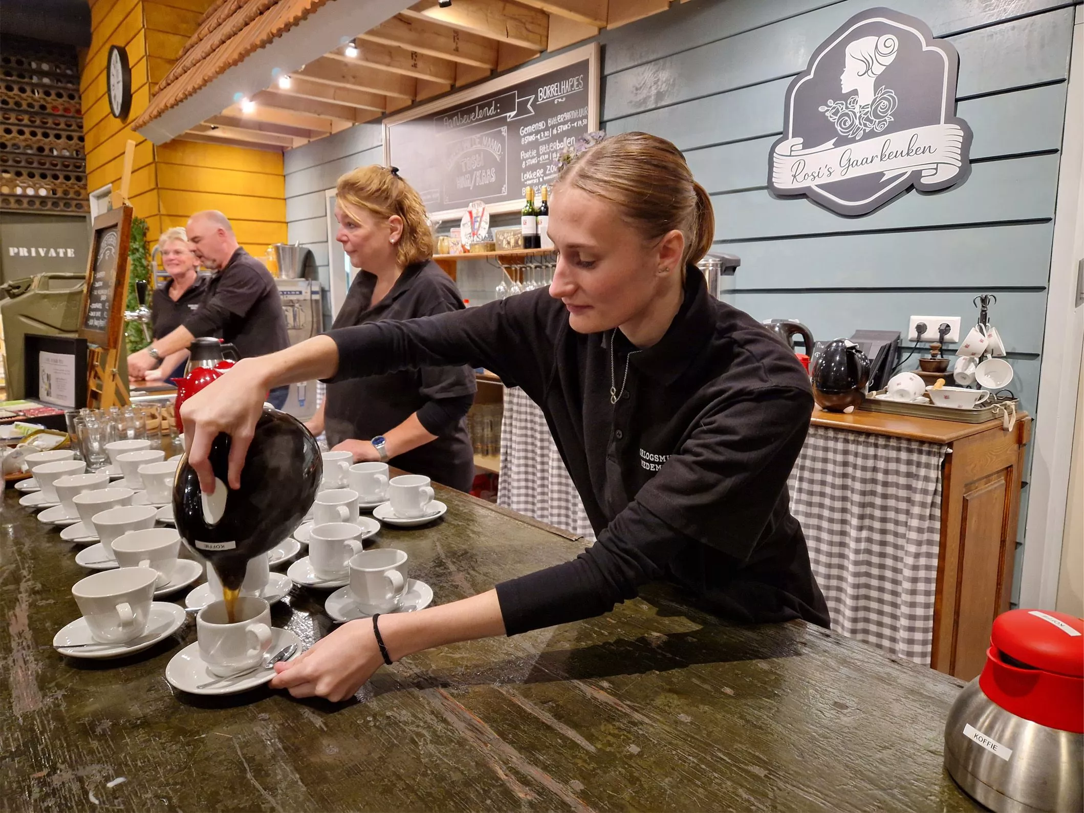 Vrijwilligers schenken koffie en thee in voor museumbezoekers en bedienen ze met lekker gebak vanuit het museumcafé