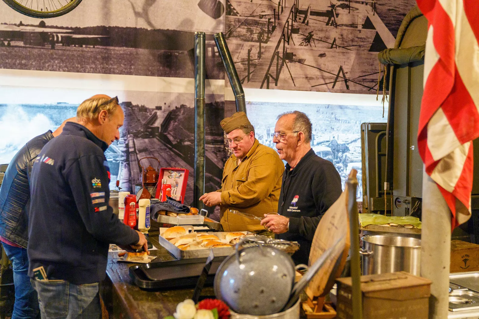 Museumbezoekers scheppen eten van het leger op wat gemaakt is op veldkeukens uit de Tweede Wereldoorlog in een Oorlogsmuseum