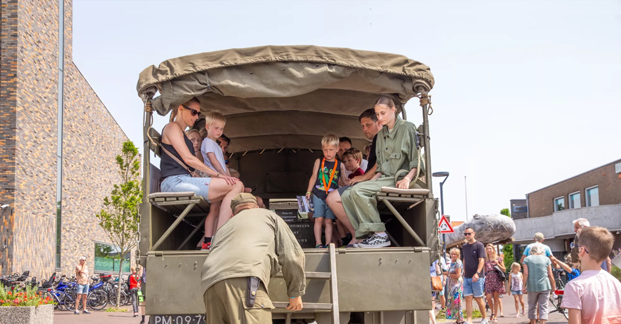 Rondrit legervoertuigen met bezoekers tijdens een herdenkingsevenement over de Tweede Wereldoorlog