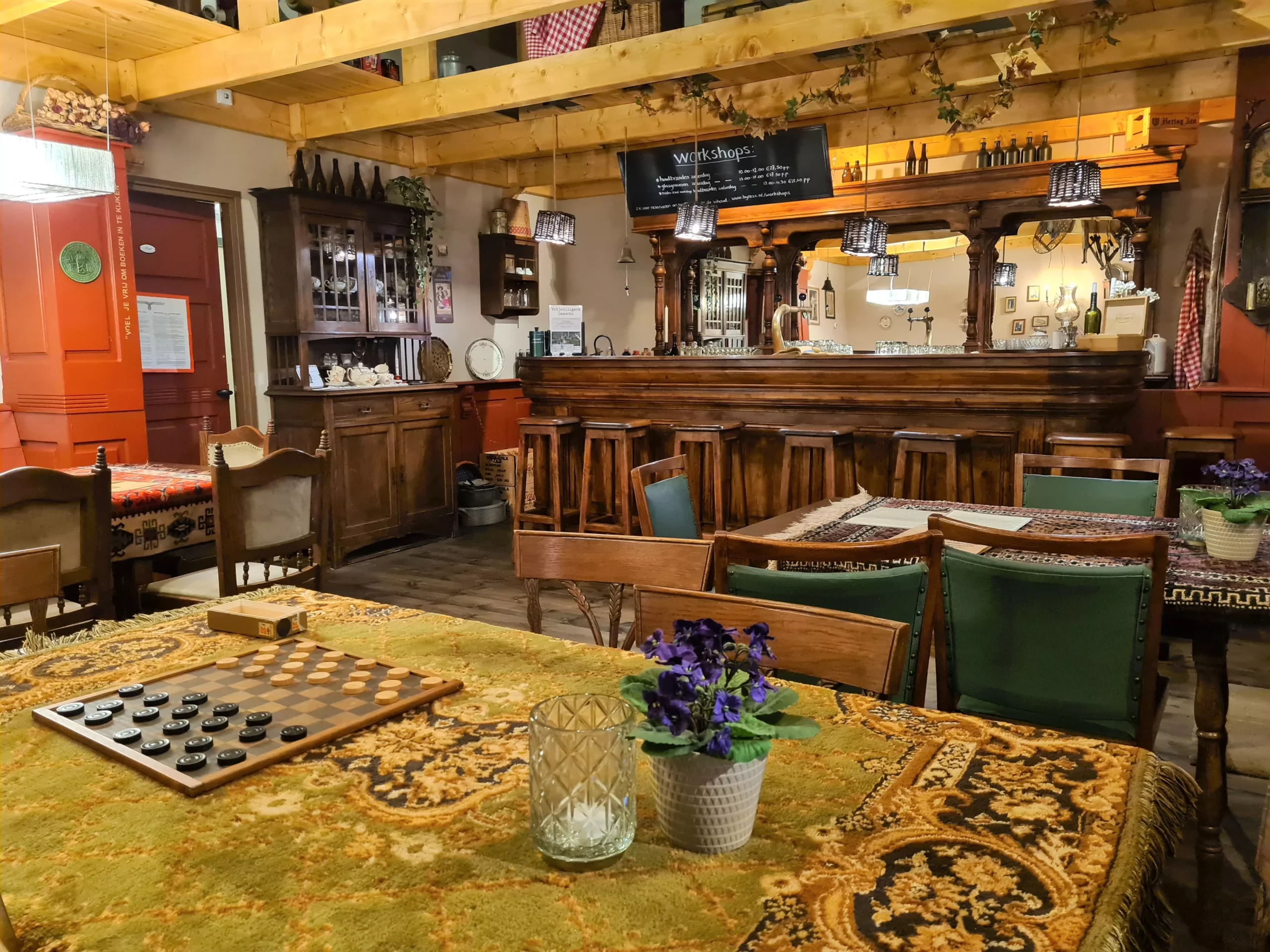 Een oude tafel met tafelkleed en stoelen in het oude bruincafé van een Oorlogsmuseum