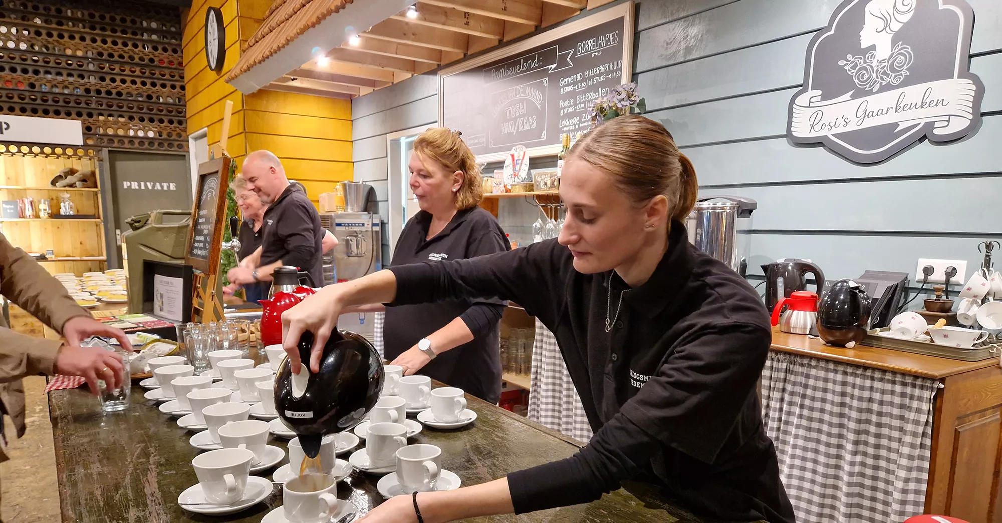 Stagiair loopt stage in een leuk museum dat erkend leerbedrijf is, stagiair schenkt koffie voor bezoekers en staat achter de bar