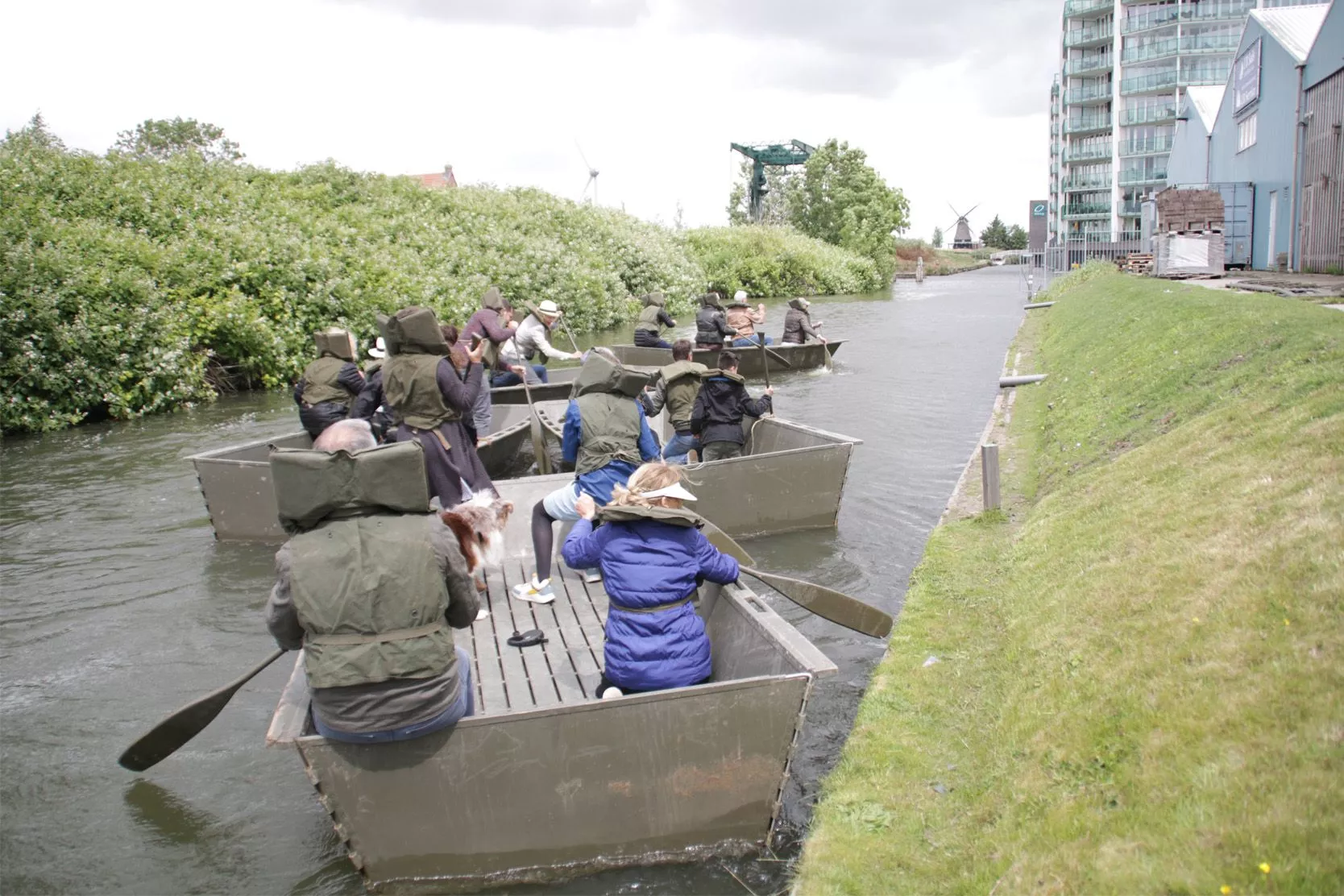 Mensen doen leuke activiteiten in een echt doe-museum wat geschikt is voor groepen van alle leeftijden, zoals een peddelwedstrijd op het water