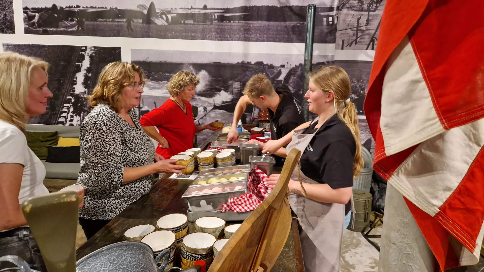 Bezoekers scheppen ijs op van het schepijsbuffet en genieten van lekker avondeten tijdens een leuk dagje uit in een leuk museum over de W.O.II